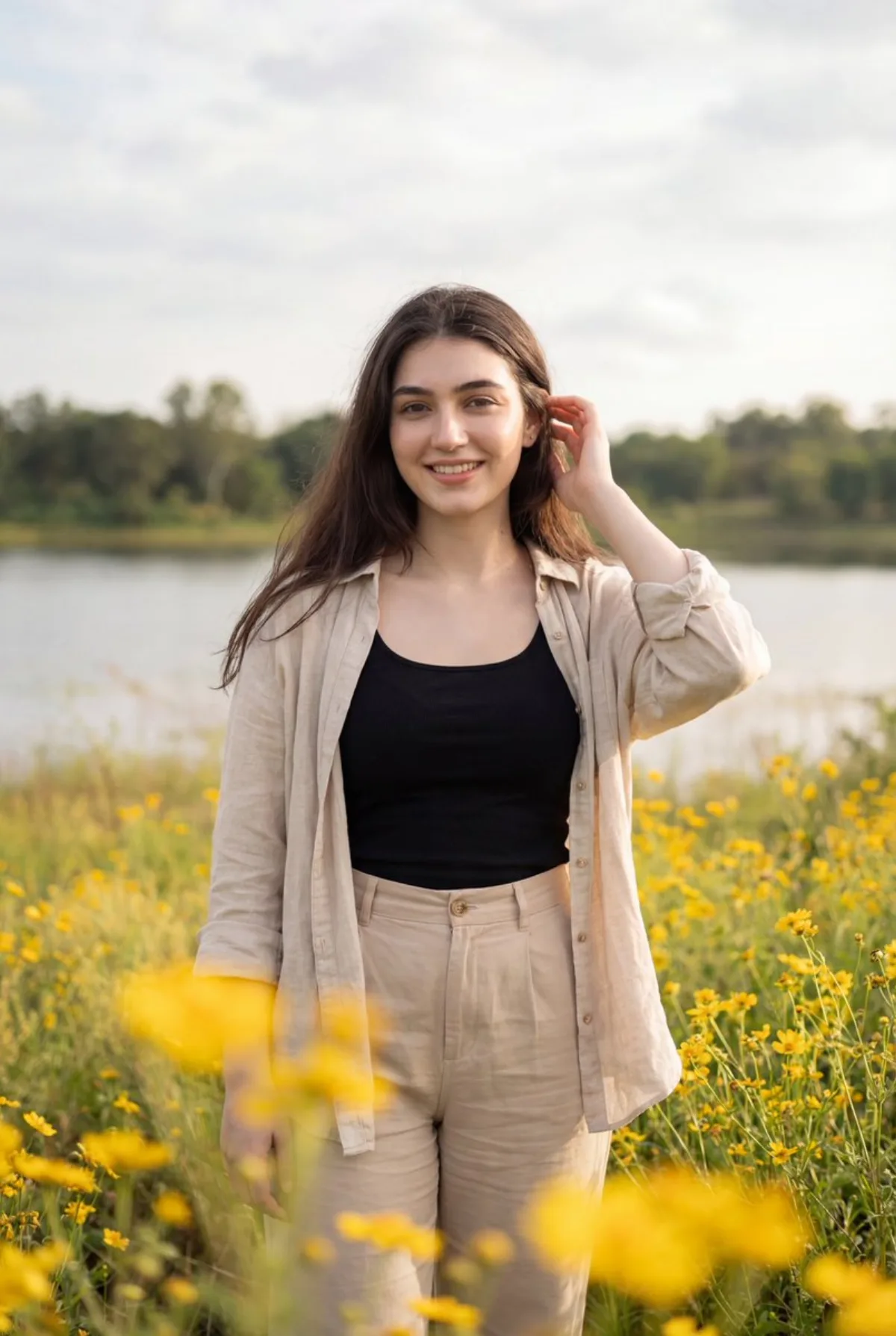Smiling Woman in Wildflower Field, Lake Background (Editorial)